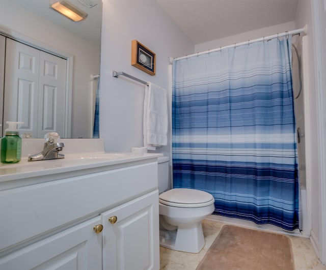 bathroom featuring toilet, vanity, walk in shower, and tile patterned floors