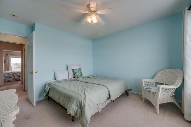 bedroom with ceiling fan, baseboards, and light colored carpet