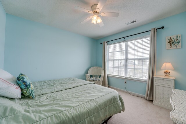 bedroom featuring ceiling fan, carpet flooring, and a textured ceiling