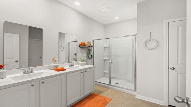 bathroom with walk in shower, vanity, and tile patterned floors