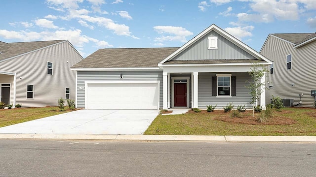 view of front of property with a front yard, a garage, covered porch, and central AC