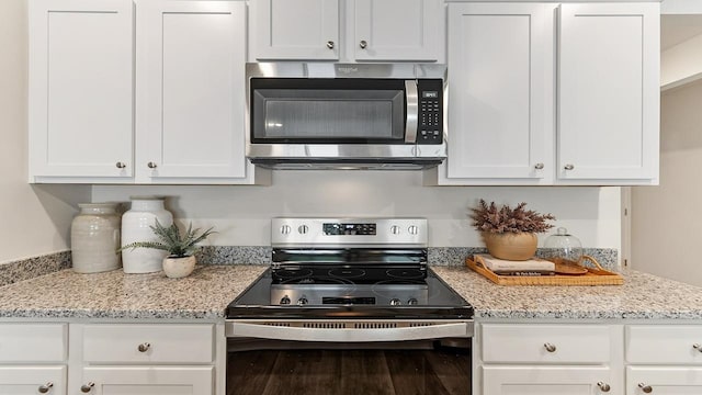 kitchen with appliances with stainless steel finishes, light stone countertops, and white cabinets