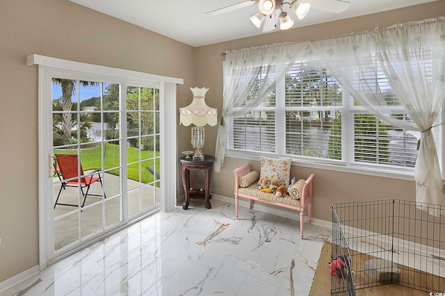 sunroom / solarium featuring ceiling fan