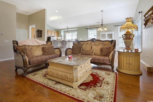 living room featuring a notable chandelier, hardwood / wood-style flooring, and vaulted ceiling