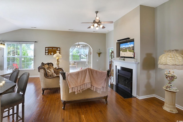 living room featuring vaulted ceiling, dark hardwood / wood-style floors, and ceiling fan