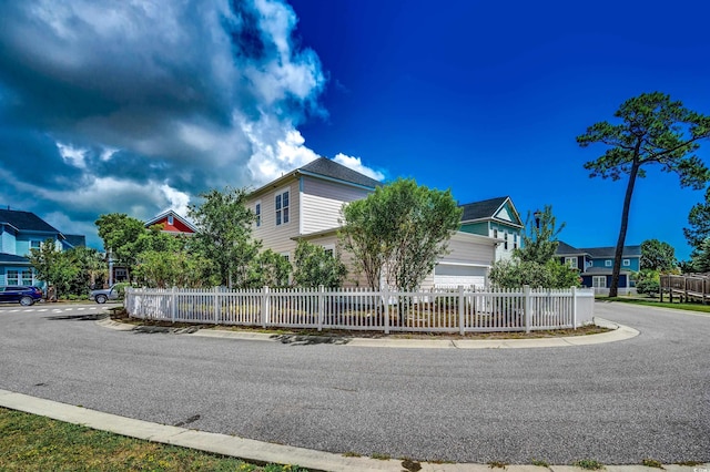 view of home's exterior with a fenced front yard and a residential view