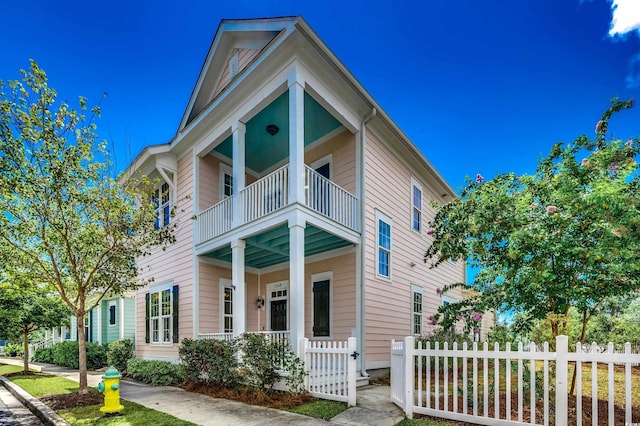 view of front facade featuring a fenced front yard and a balcony