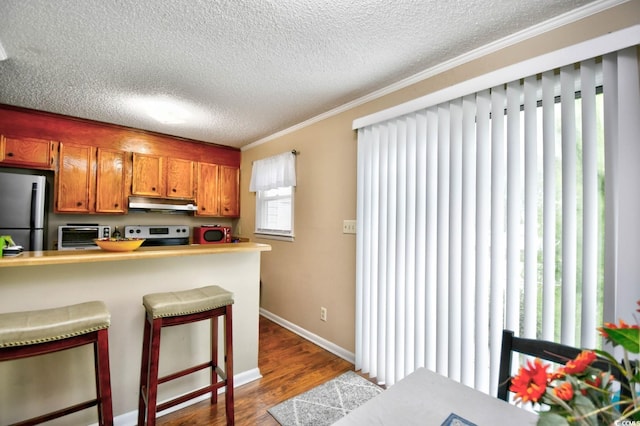 kitchen featuring hardwood / wood-style floors, range, a textured ceiling, kitchen peninsula, and stainless steel fridge