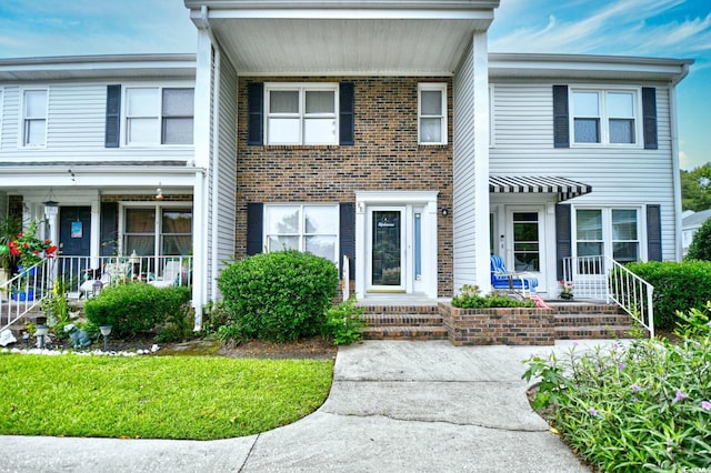 view of front of home with covered porch and brick siding