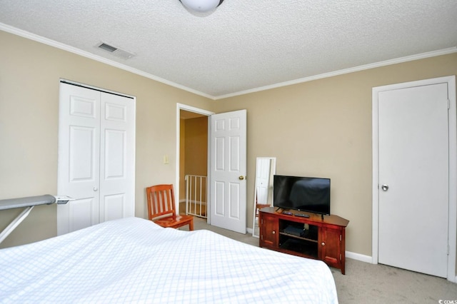 carpeted bedroom with a textured ceiling, a closet, and crown molding