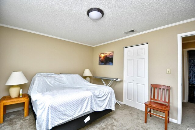 carpeted bedroom featuring a closet, a textured ceiling, and ornamental molding