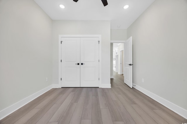 unfurnished bedroom with ceiling fan, a closet, and light hardwood / wood-style flooring