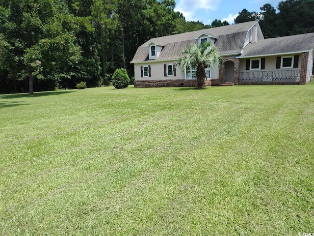 view of front facade featuring a shingled roof and a front lawn