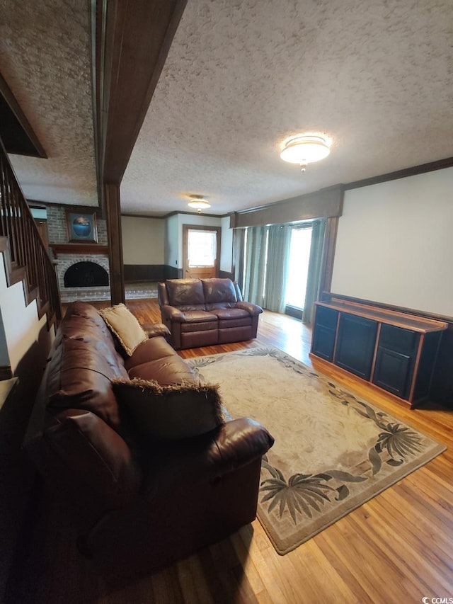 living room featuring a textured ceiling, hardwood / wood-style floors, and a fireplace