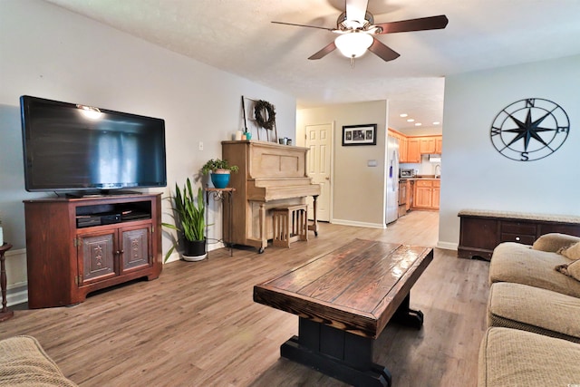 living room featuring light hardwood / wood-style floors and ceiling fan