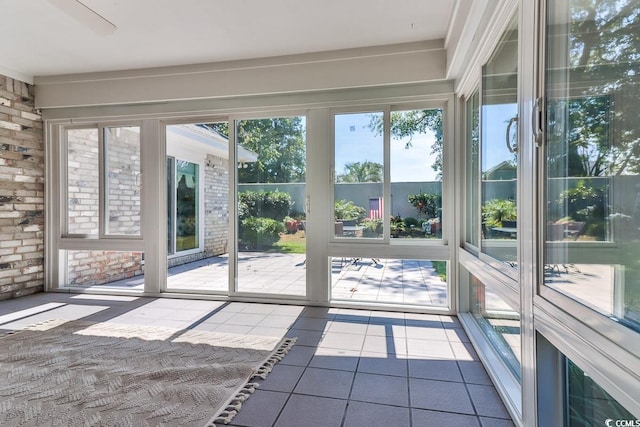 unfurnished sunroom featuring ceiling fan