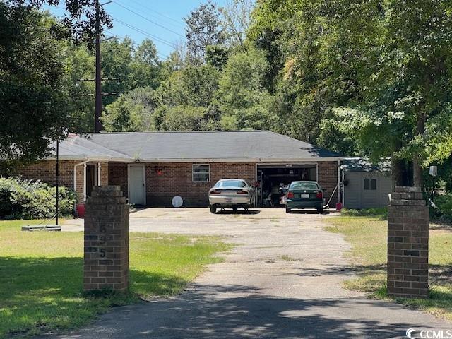 single story home featuring a garage and a front yard