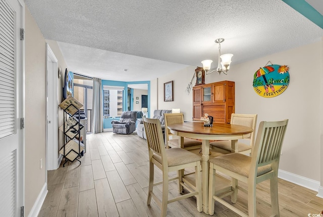5308 N Ocean Blvd Unit 812, Myrtle Beach, SC 29577 - dining space with a textured ceiling, light wood-style flooring, baseboards, and a chandelier