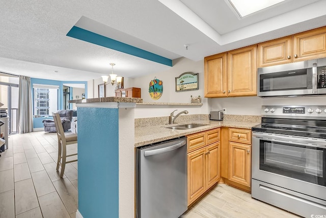 5308 N Ocean Blvd Unit 812, Myrtle Beach, SC 29577 - kitchen with stainless steel appliances, a sink, a peninsula, a chandelier, and light stone countertops