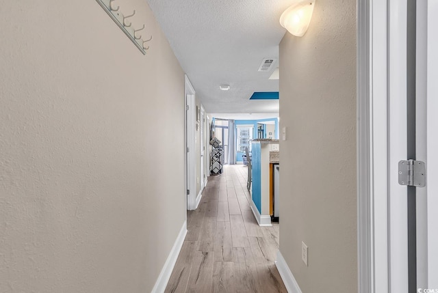 5308 N Ocean Blvd Unit 812, Myrtle Beach, SC 29577 - hallway with baseboards, light wood finished floors, a textured ceiling, and a textured wall