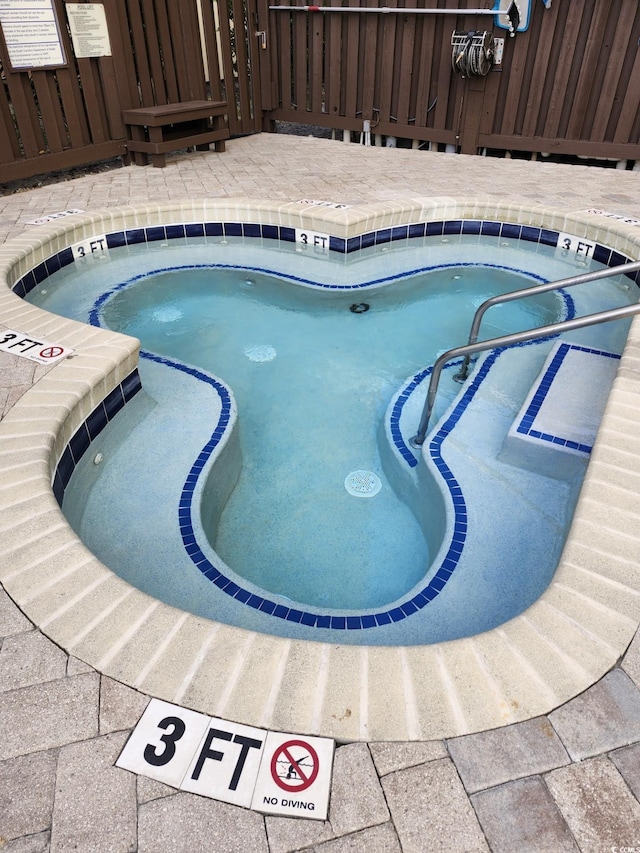 view of pool featuring an in ground hot tub