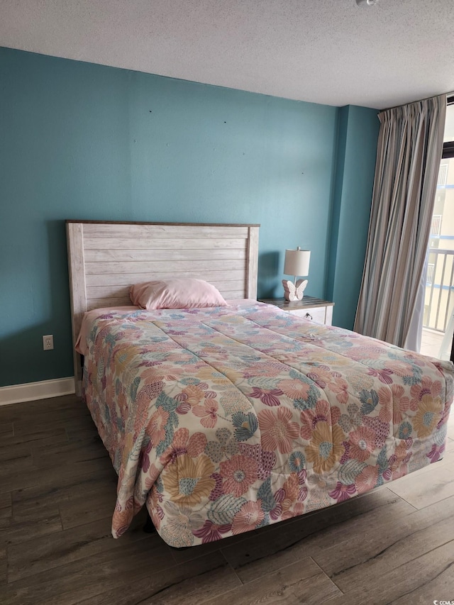 bedroom featuring dark wood-type flooring and a textured ceiling