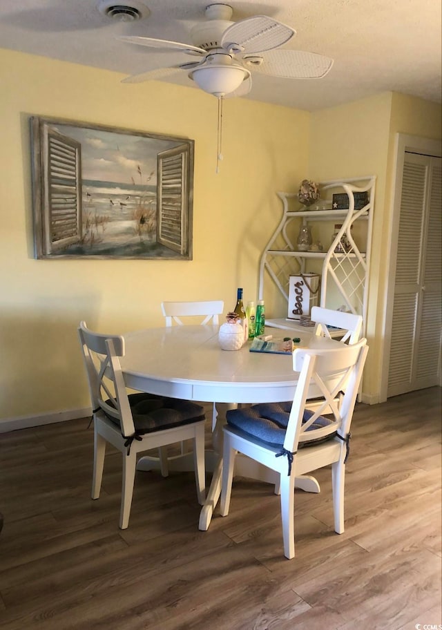 dining space featuring ceiling fan and hardwood / wood-style floors