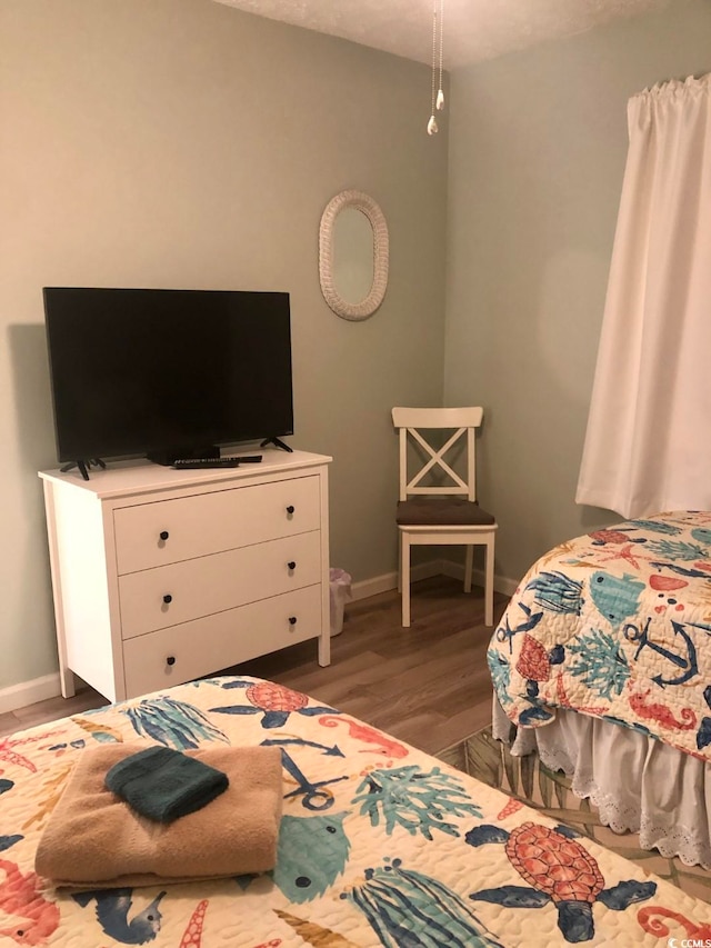 bedroom with dark hardwood / wood-style flooring