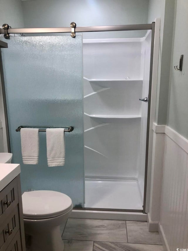 bathroom with vanity, a shower with shower door, and toilet