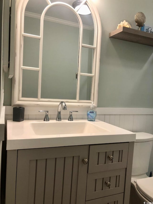 bathroom featuring ornamental molding, vanity, and toilet