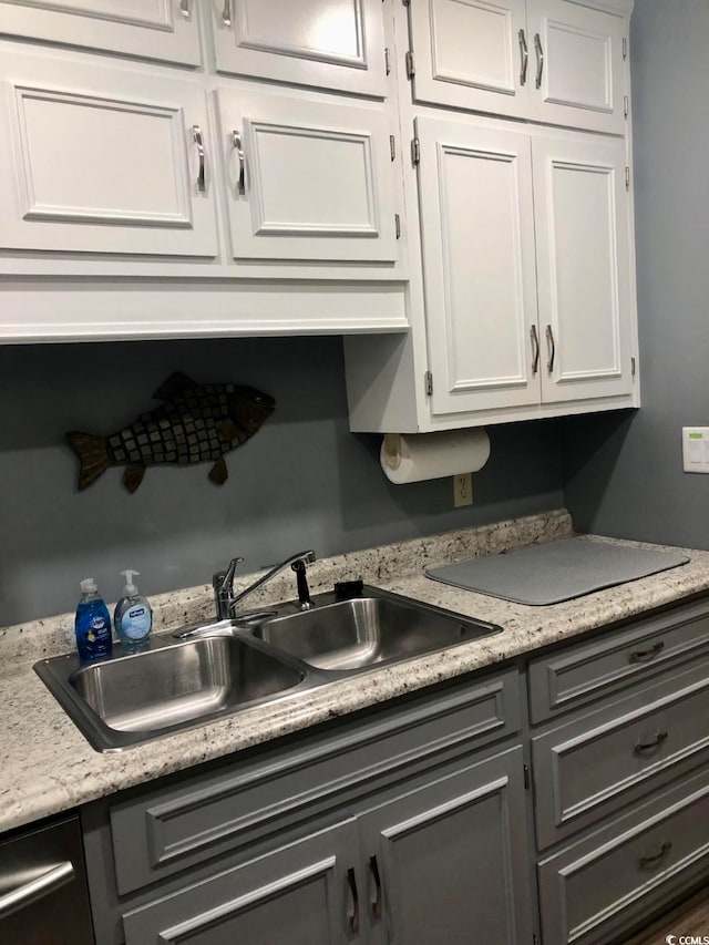 kitchen featuring white cabinetry and sink