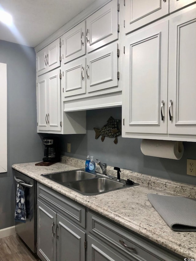 kitchen featuring white cabinets, stainless steel dishwasher, dark hardwood / wood-style floors, and sink