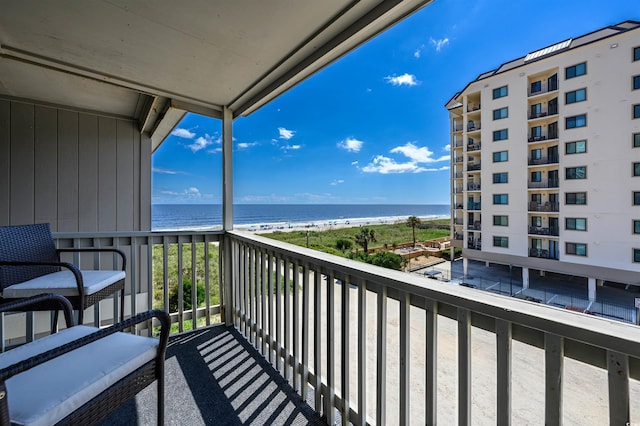 balcony featuring a view of the beach and a water view