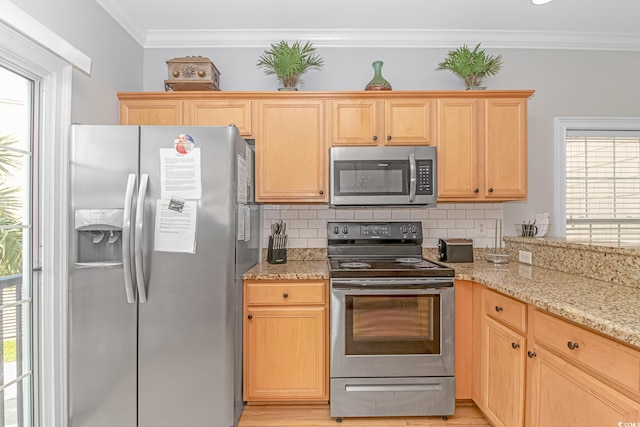 kitchen featuring a wealth of natural light, stainless steel appliances, ornamental molding, and tasteful backsplash