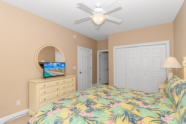 carpeted bedroom with ceiling fan and a closet