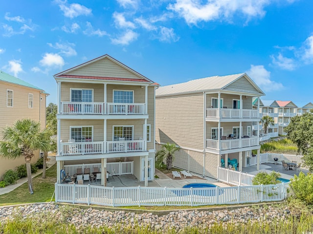 rear view of property with a balcony and a patio area