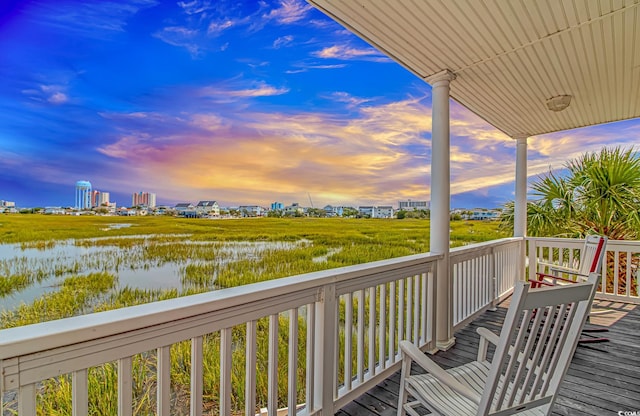 balcony at dusk with a deck with water view