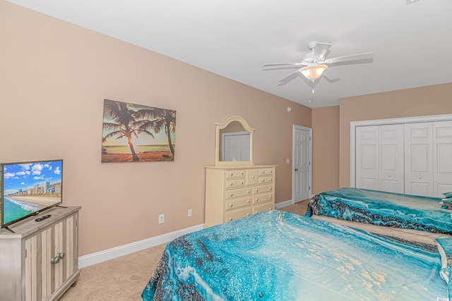 carpeted bedroom featuring ceiling fan and a closet