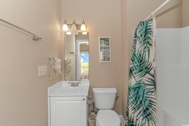 bathroom featuring toilet, curtained shower, and vanity