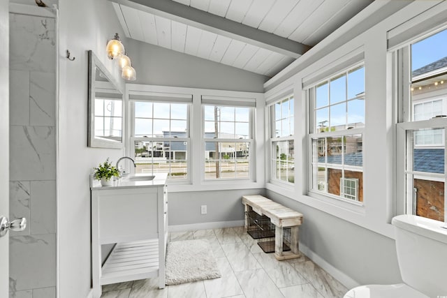 sunroom featuring lofted ceiling with beams and sink