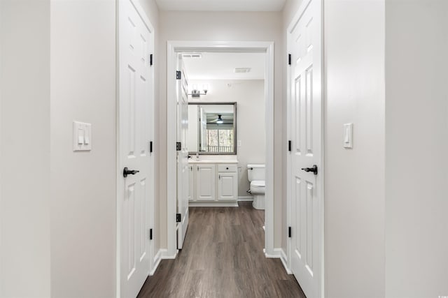 hallway featuring dark wood finished floors and visible vents