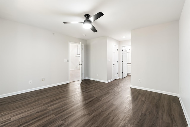 spare room featuring ceiling fan, dark wood-type flooring, and baseboards