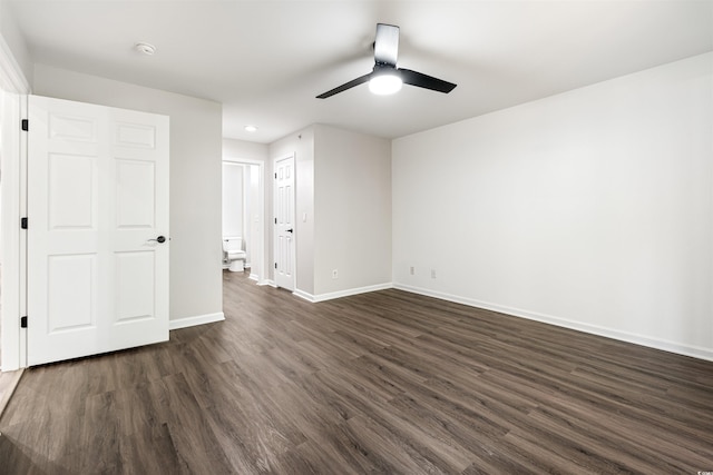 empty room featuring dark wood finished floors, baseboards, and ceiling fan