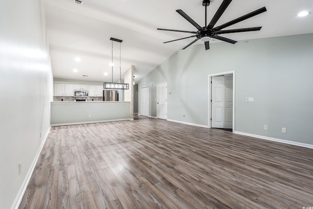 unfurnished living room featuring dark wood finished floors, recessed lighting, a ceiling fan, high vaulted ceiling, and baseboards