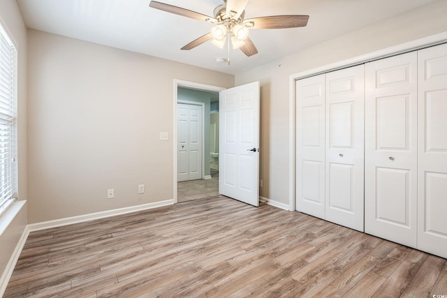 unfurnished bedroom with light wood-style floors, a ceiling fan, baseboards, and a closet