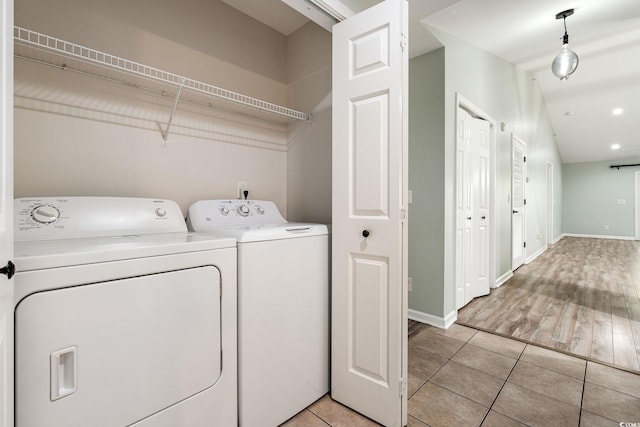 washroom with baseboards, laundry area, light tile patterned flooring, and washer and dryer