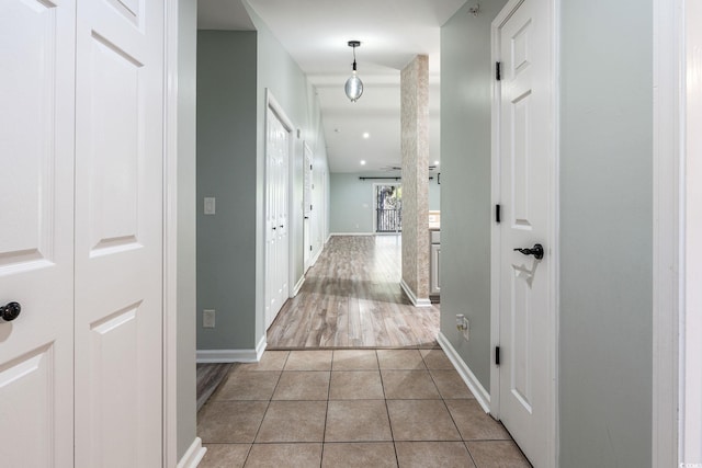 hall with baseboards and light tile patterned floors