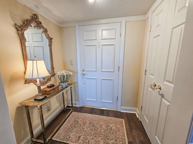 foyer with a textured ceiling, dark wood-type flooring, and crown molding