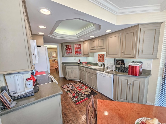 kitchen featuring dark wood-type flooring, sink, white appliances, a raised ceiling, and crown molding