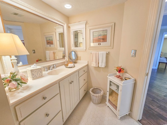 bathroom featuring a textured ceiling, hardwood / wood-style flooring, and vanity